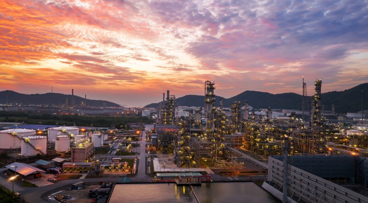 Crude Oil Refinery Plant Steel Pipe line and Chimney and Cooling tower, Chemical or Petrochemical factory plant power plant, Petrochemical tower tank industry at sunset